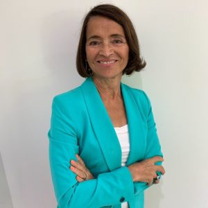 Cynthia Cannady, especialista em propriedade intelectual e transferência de tecnologia, sorrindo para a câmera, vestindo um blazer azul-turquesa e com os braços cruzados.
